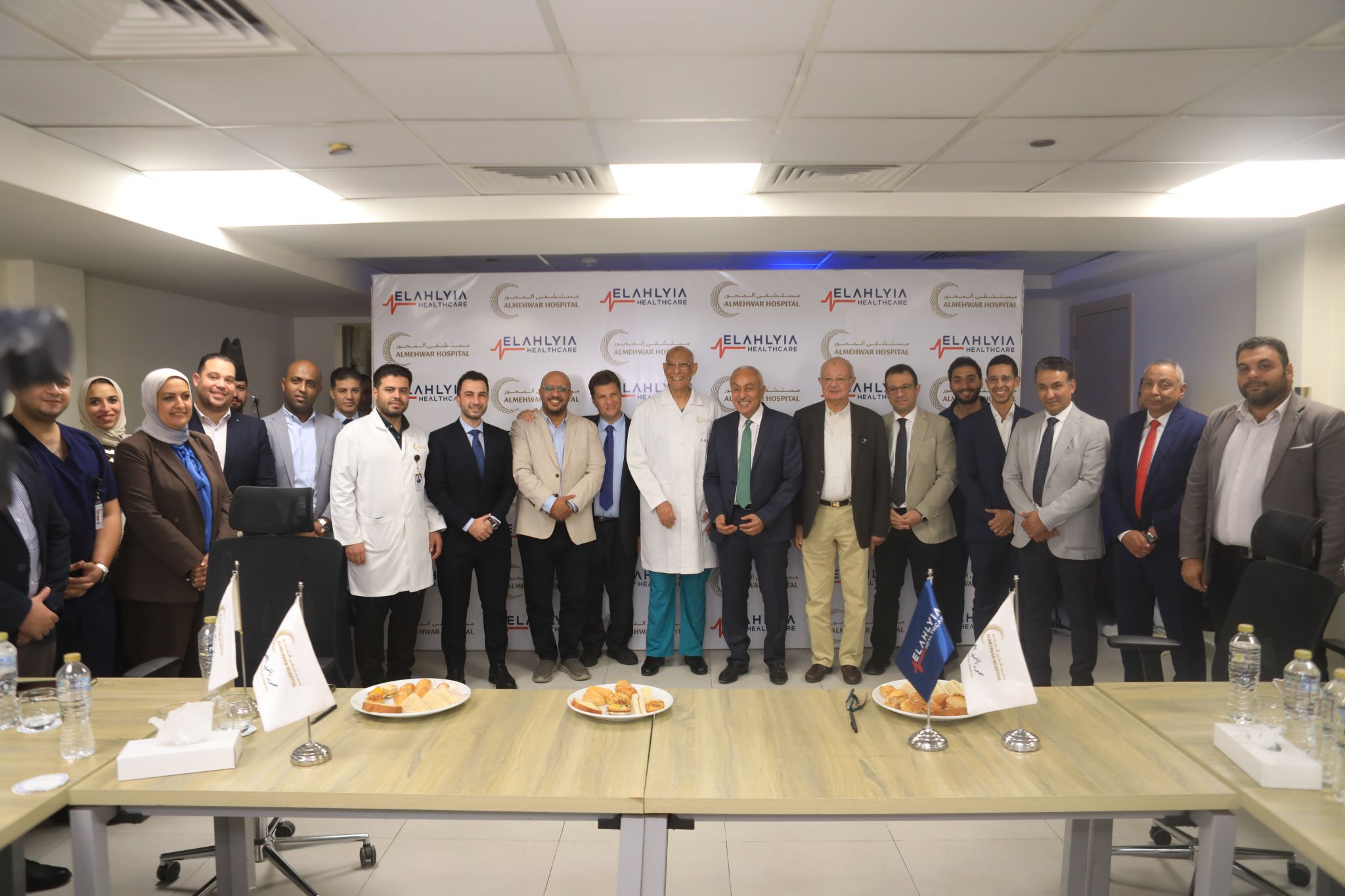 Group photo of the El Ahlyia Healthcare and Al Mehwar Hospital attendees at the signing